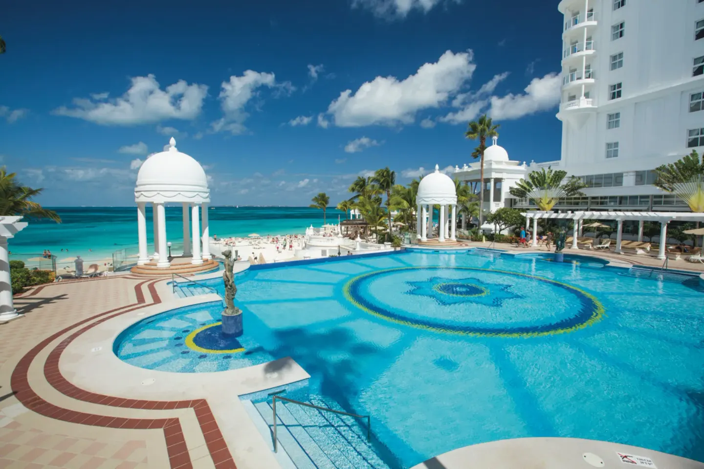Beachfront pool, domed gazebo, and hotel tower at Hotel Riu Palace Las Americas.