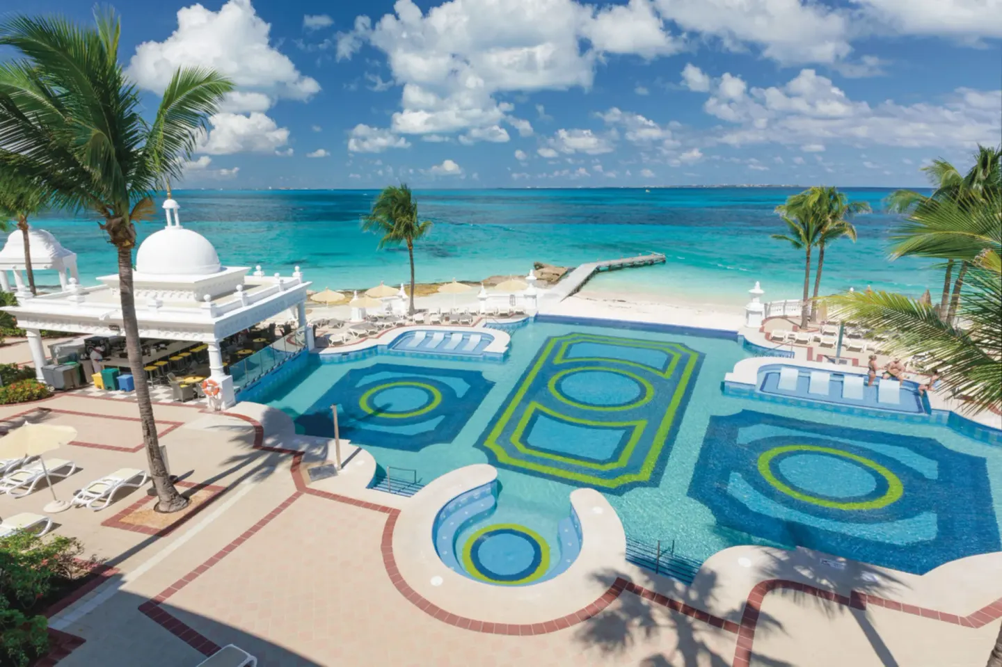 Pool terrace with domed pavilion and Caribbean beach at Hotel Riu Palace Las Americas.
