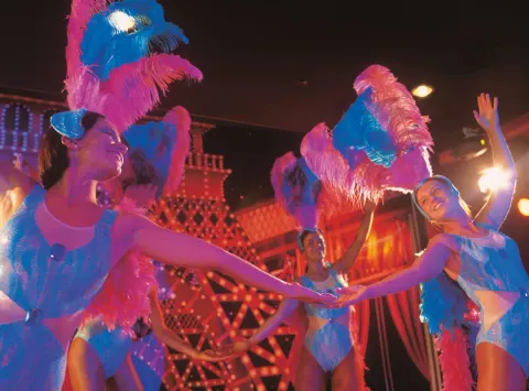 Feathered show dancers in blue costumes at Hotel Riu Palace Las Americas.