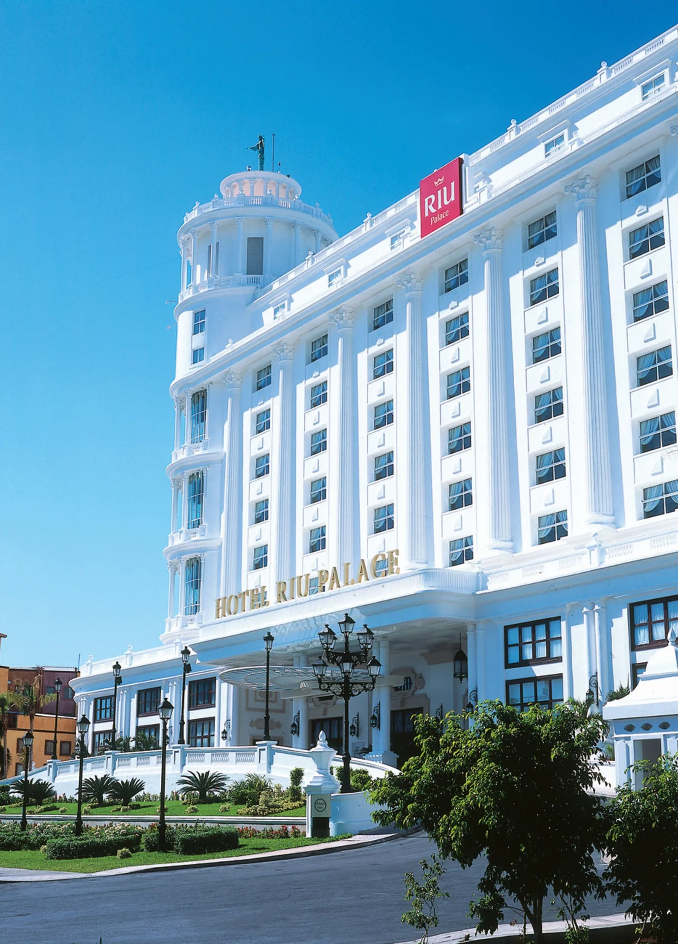 White entrance facade and tower of Hotel Riu Palace Las Americas.