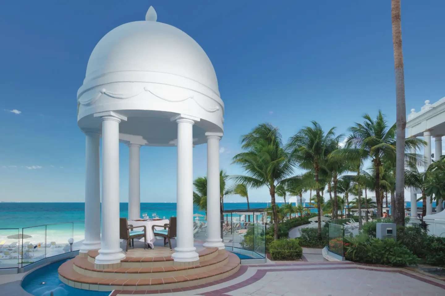 White domed gazebo and palm-lined ocean terrace at Hotel Riu Palace Las Americas.