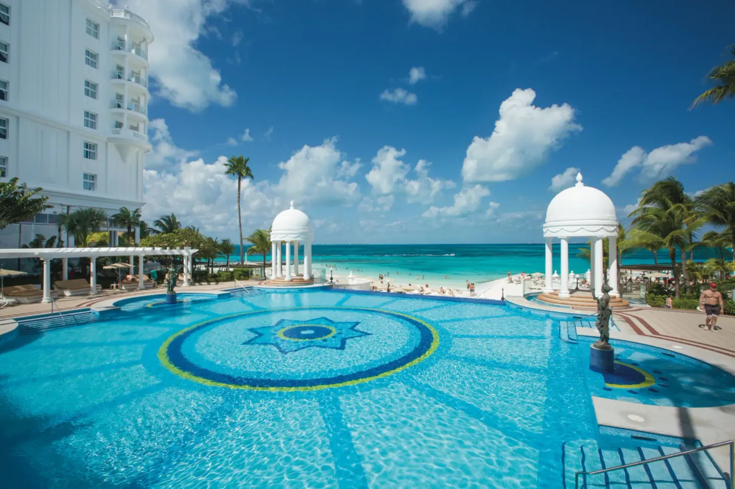 Large oceanfront pool with domed gazebos and beach at Hotel Riu Palace Las Americas.
