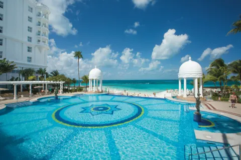 Large oceanfront pool with domed gazebos and beach at Hotel Riu Palace Las Americas.
