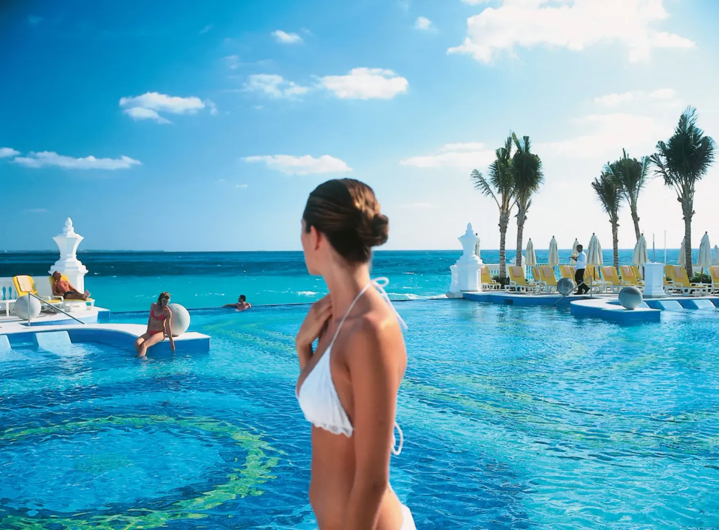 Guests by the oceanfront pool at Hotel Riu Palace Las Americas.
