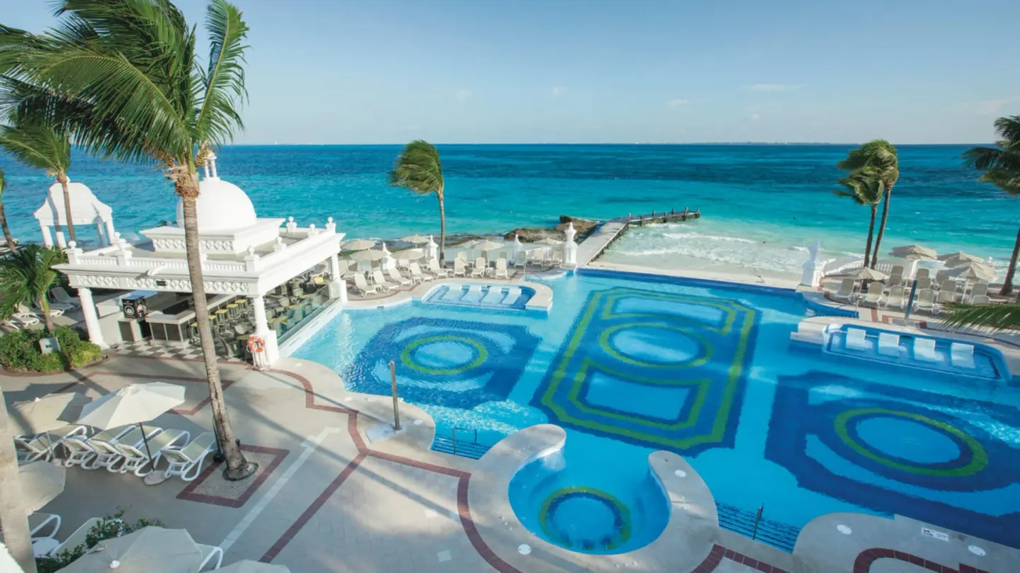 Elevated view of oceanfront pools and terraces at Hotel Riu Palace Las Americas.