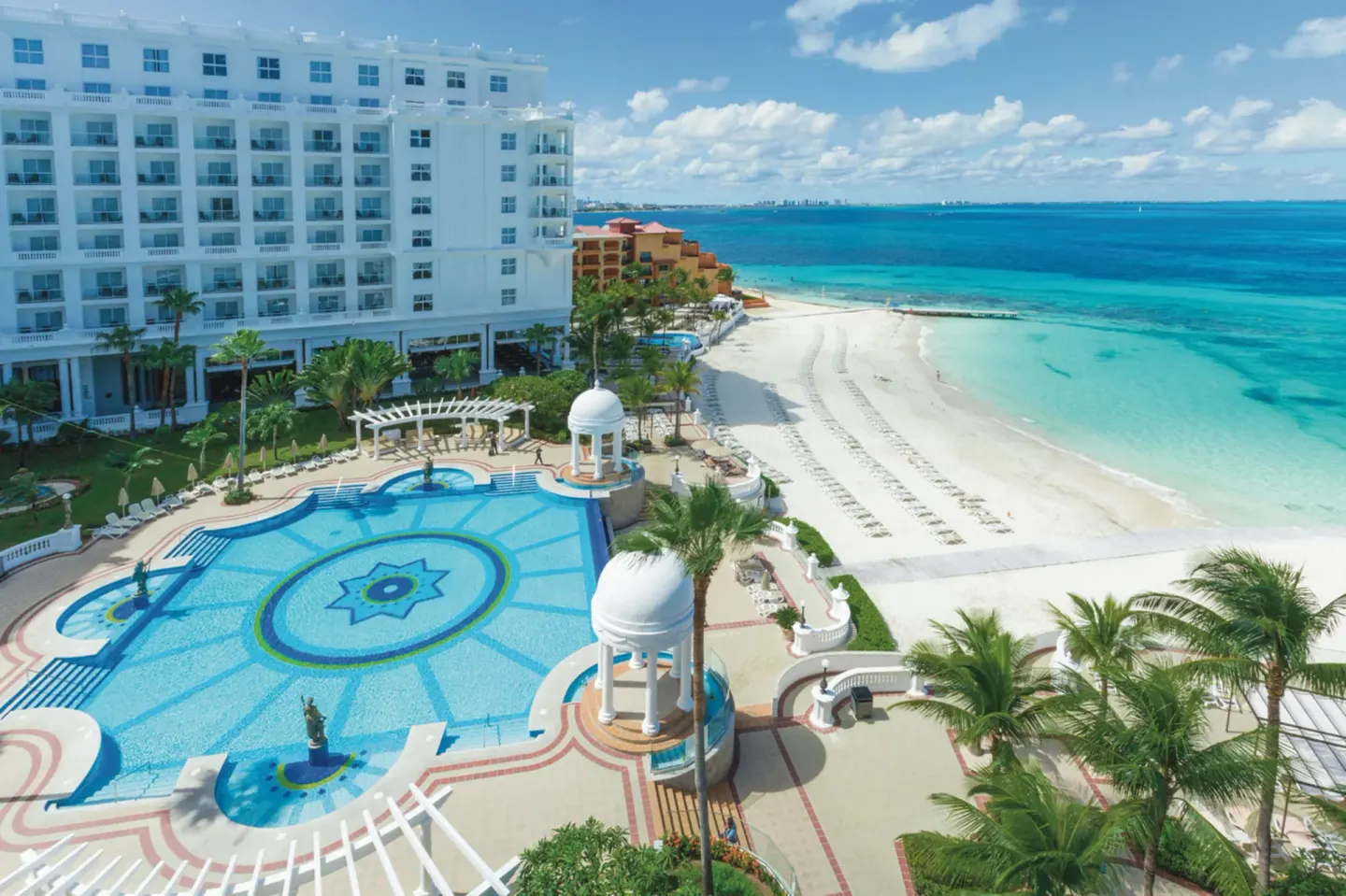 Aerial view of pool, beach, and ocean at Hotel Riu Palace Las Americas.