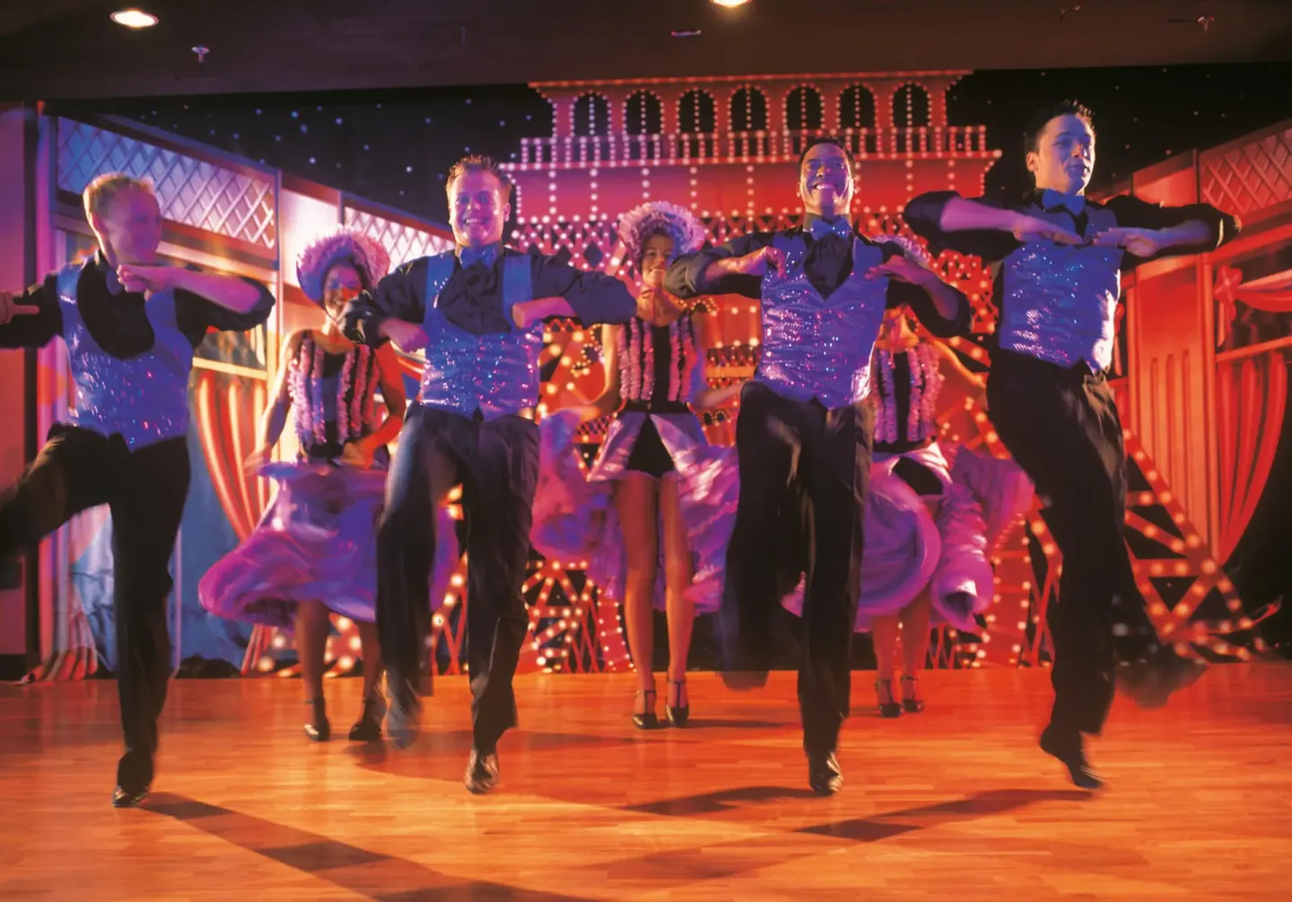 Stage dancers in sparkling costumes performing at Hotel Riu Palace Las Americas.