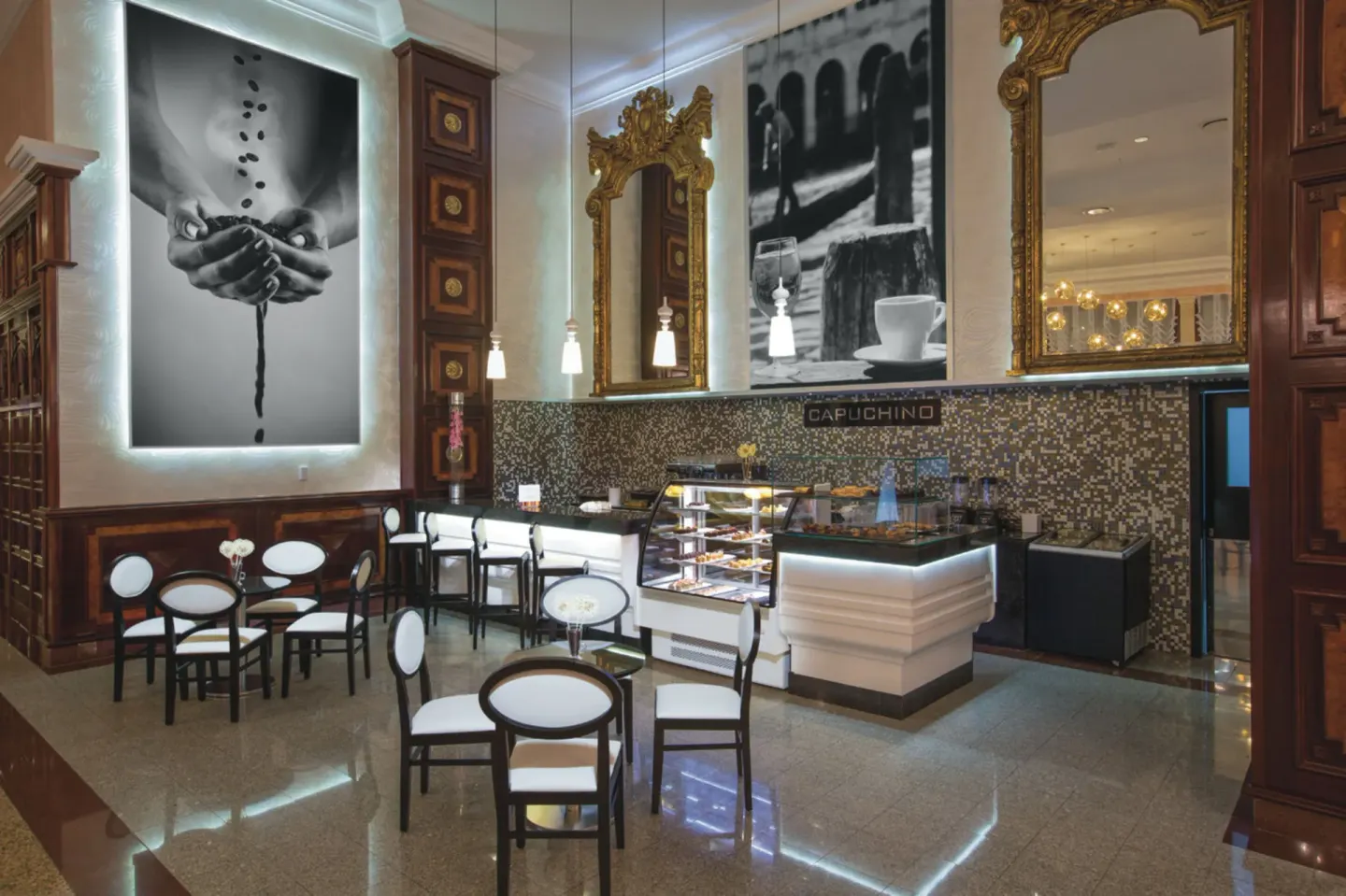 Capuchino cafe with pastry cases and small tables at Hotel Riu Palace Las Americas.