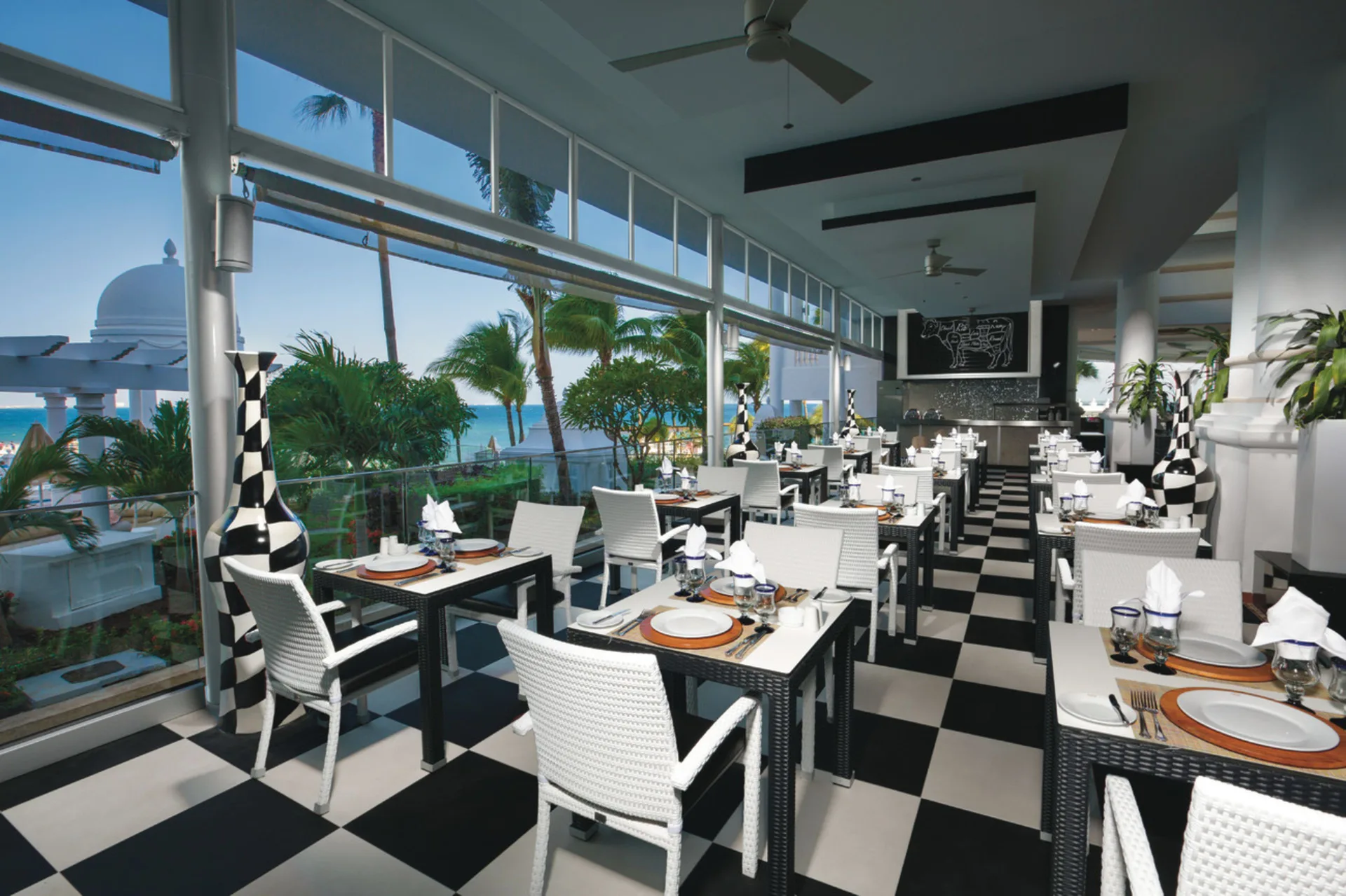 Bright dining room with ocean-facing windows at Hotel Riu Palace Las Americas.