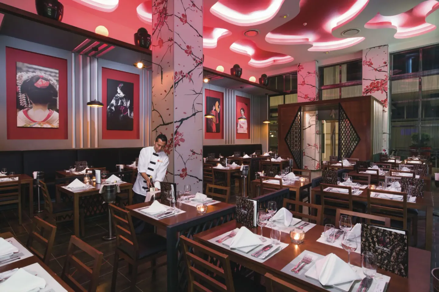 Japanese-style restaurant dining room with pink lighting at Hotel Riu Palace Las Americas.