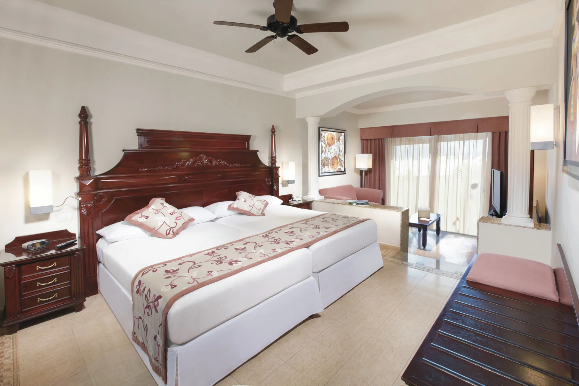 Junior Suite bedroom with king bed and sitting area at Hotel Riu Palace Las Americas.