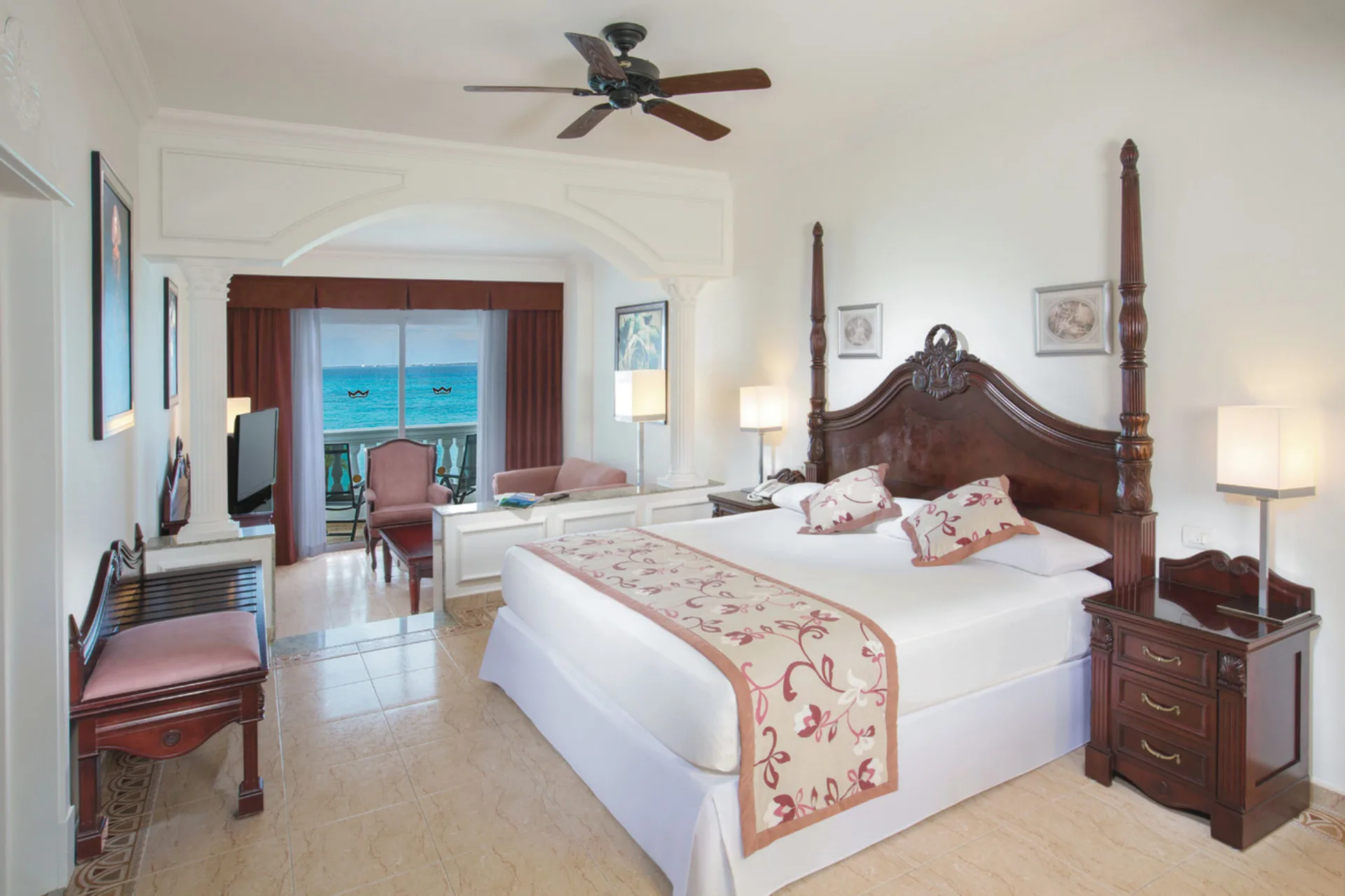 Ocean view suite bedroom with king bed and balcony at Hotel Riu Palace Las Americas.