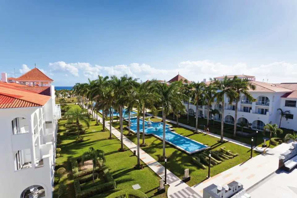 Landscaped central pool and palm-lined walkway viewed from above at Hotel Riu Palace Mexico