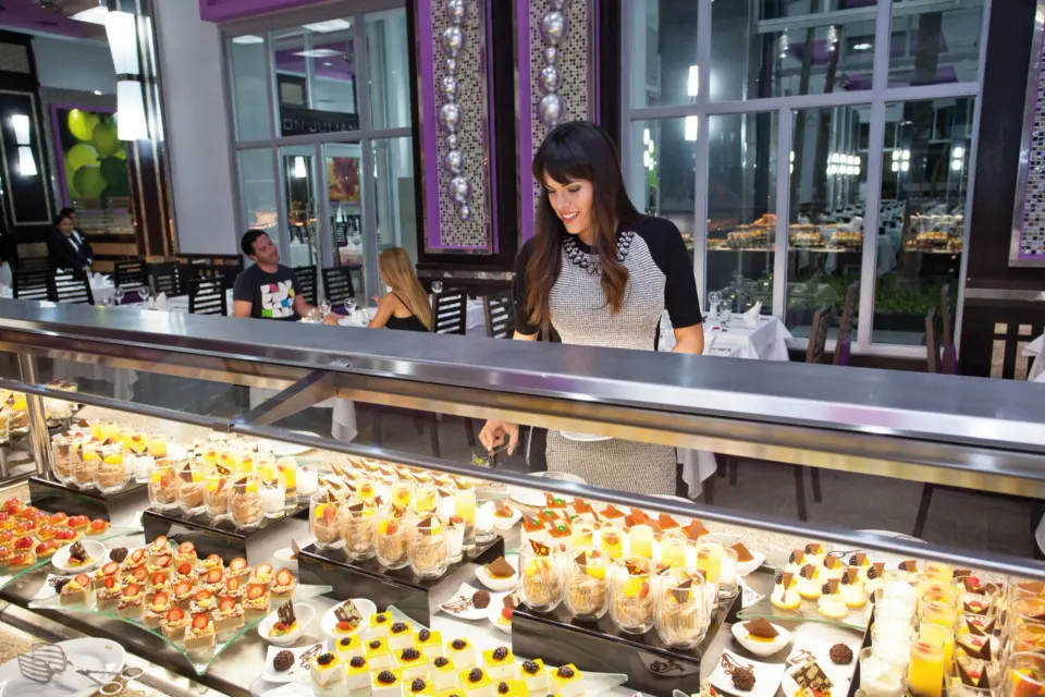 Guest selecting desserts from a chilled display at Hotel Riu Palace Mexico
