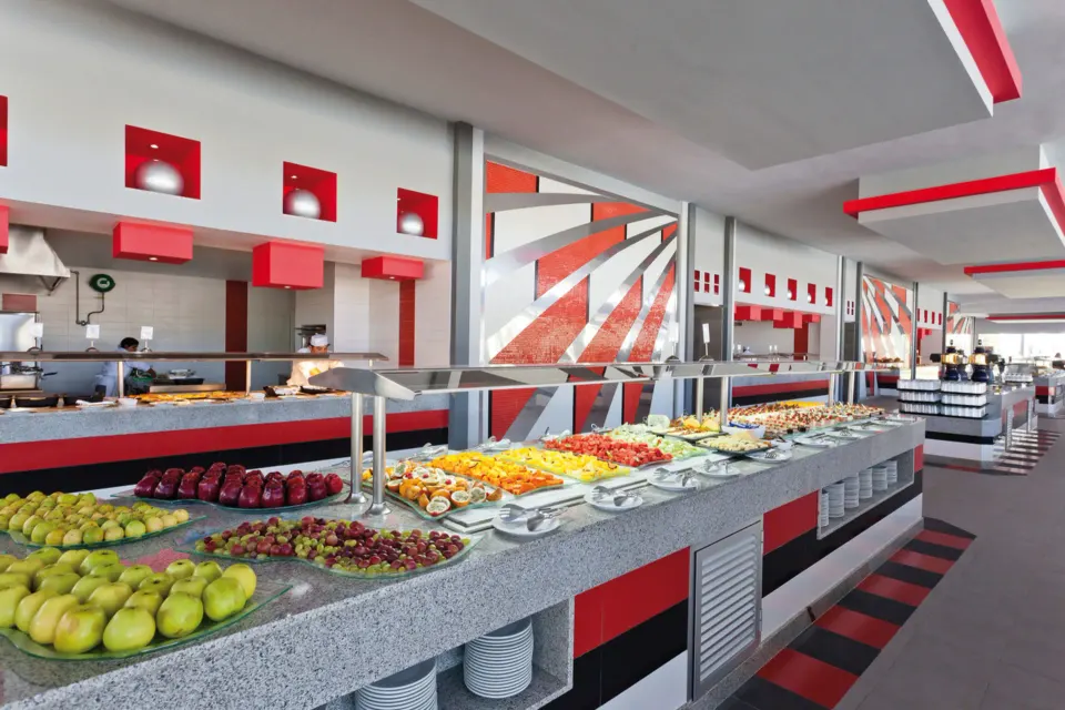 Long self-serve buffet counter with fruit and hot food at Hotel Riu Palace Mexico