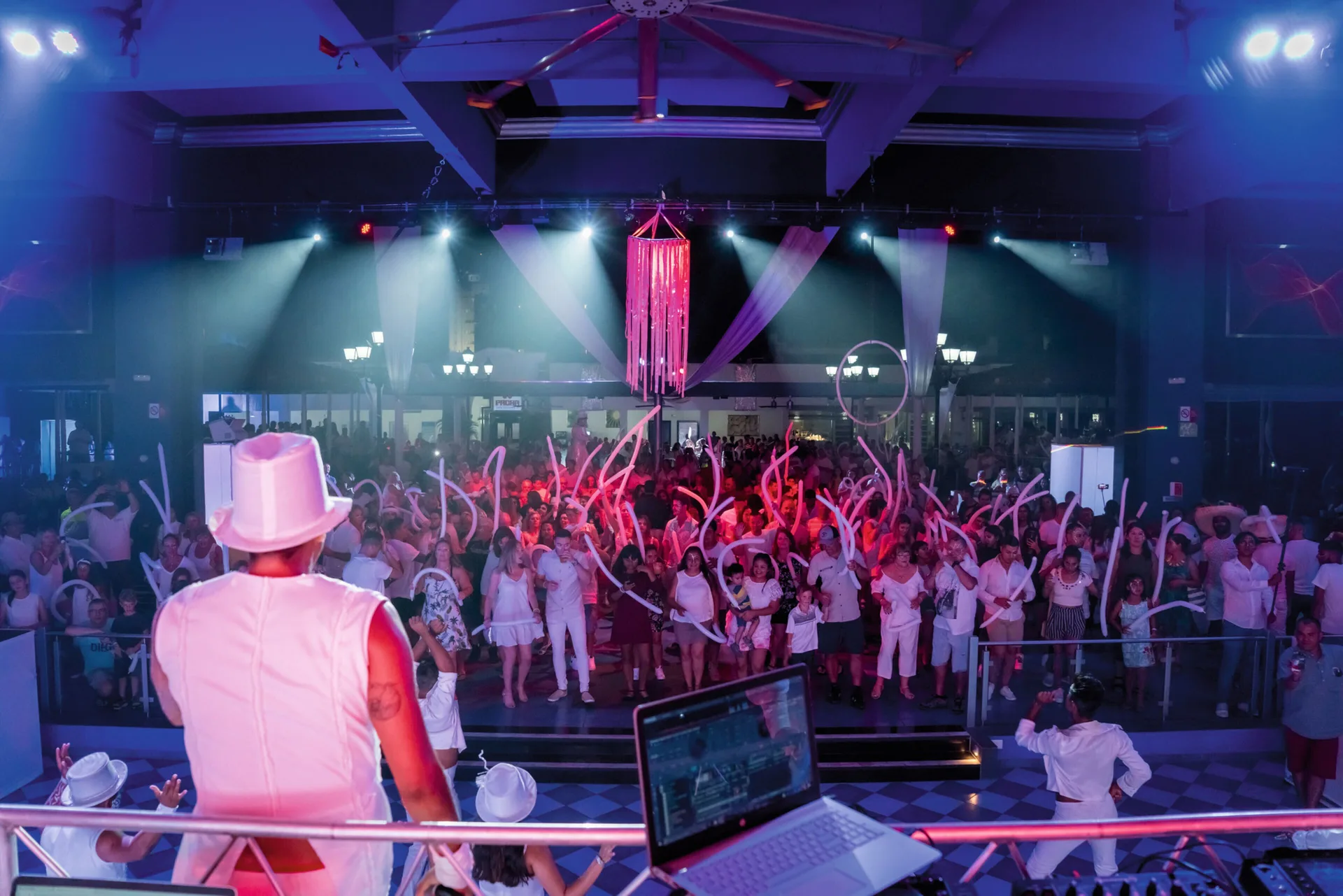 Crowd waves light sticks during a live show at Hotel Riu Palace Pacifico.