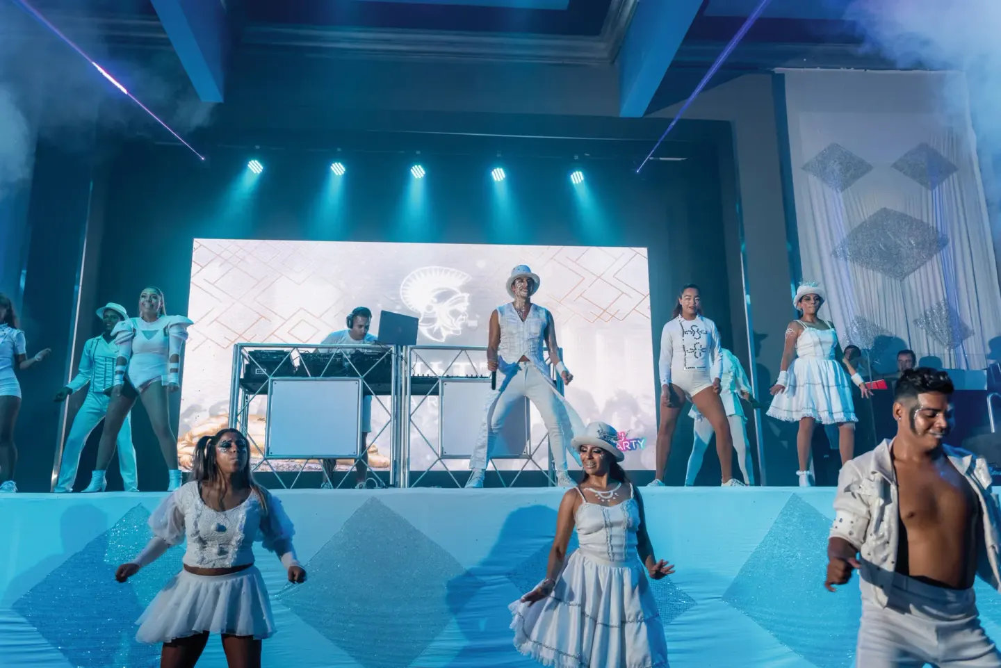 Performers and a DJ lead a bright stage show at Hotel Riu Palace Pacifico.
