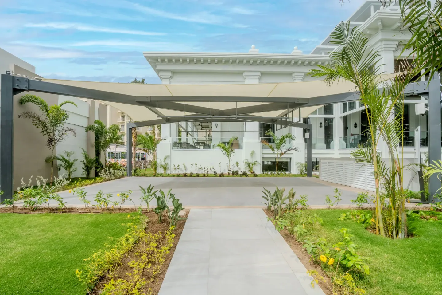 Landscaped walkway leading to a shaded activity area at Hotel Riu Palace Pacifico.