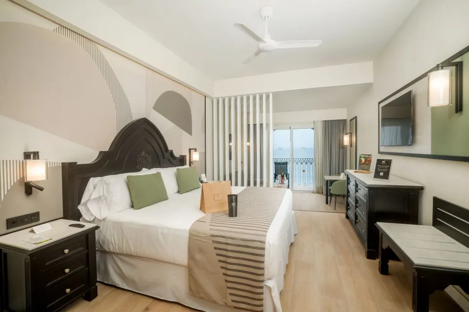 Elite Club Junior Suite Oceanfront king bed and balcony at Hotel Riu Palace Pacifico.