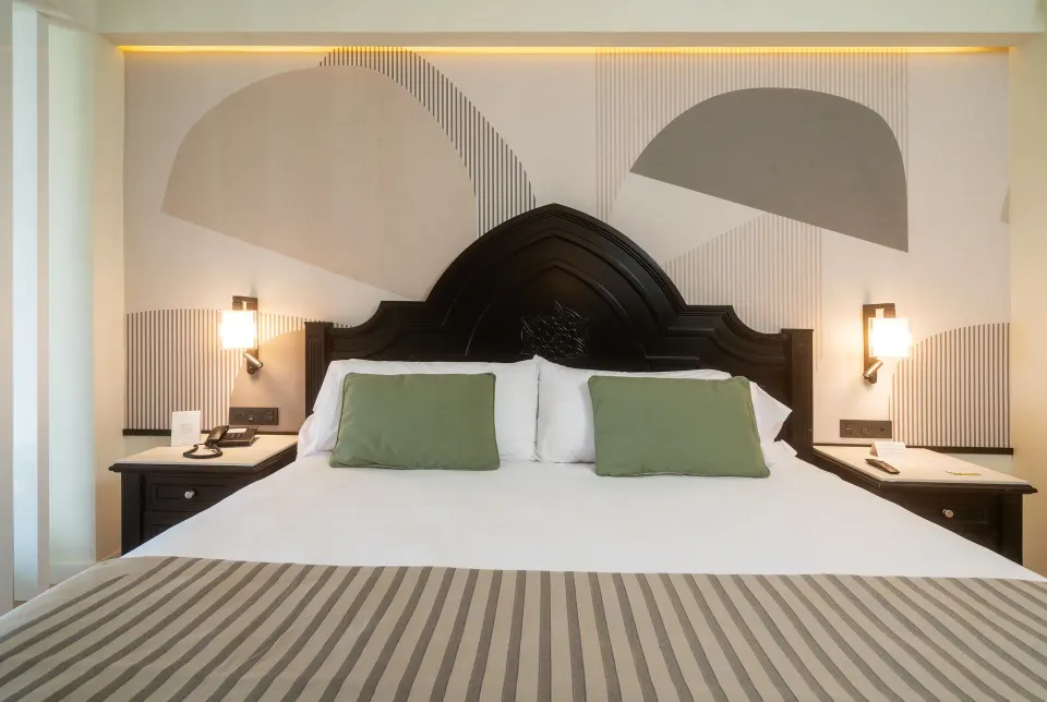 Junior Suite king bed with bedside tables at Hotel Riu Palace Pacifico.