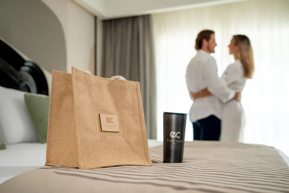 Elite Club tote and tumbler on an oceanfront suite bed at Hotel Riu Palace Pacifico.