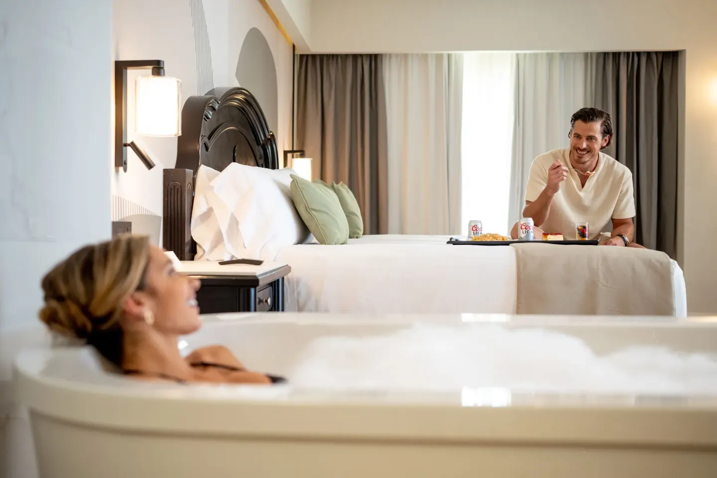 Suite with in-room tub, king bed, and breakfast tray at Hotel Riu Palace Pacifico.