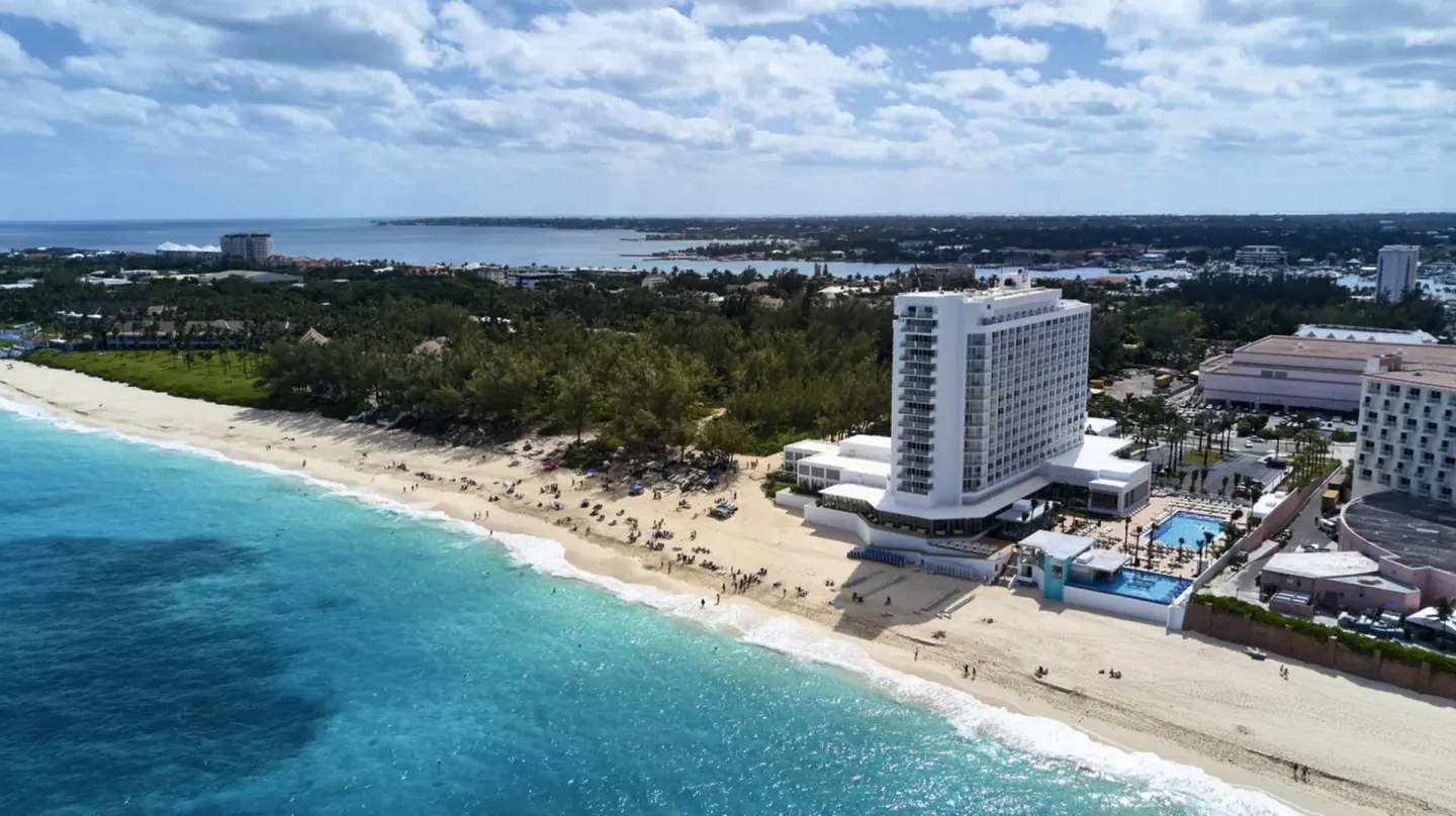 Aerial beachfront view of the resort tower and shoreline at Hotel Riu Palace Paradise Island.