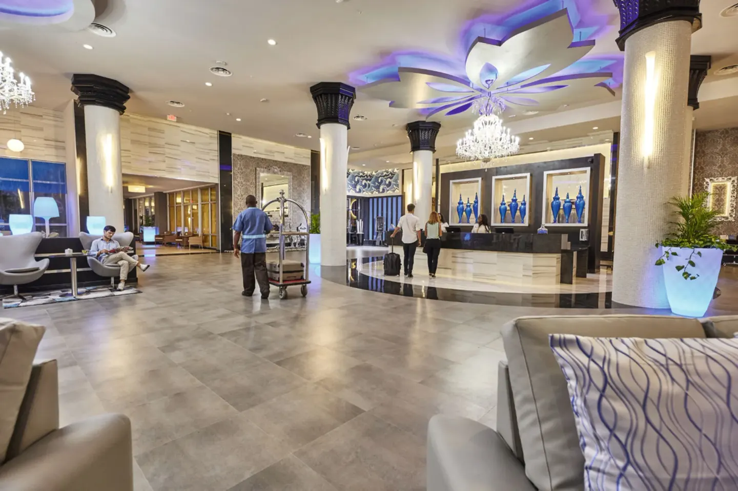 Lobby reception with chandeliers and seating at Hotel Riu Palace Paradise Island.