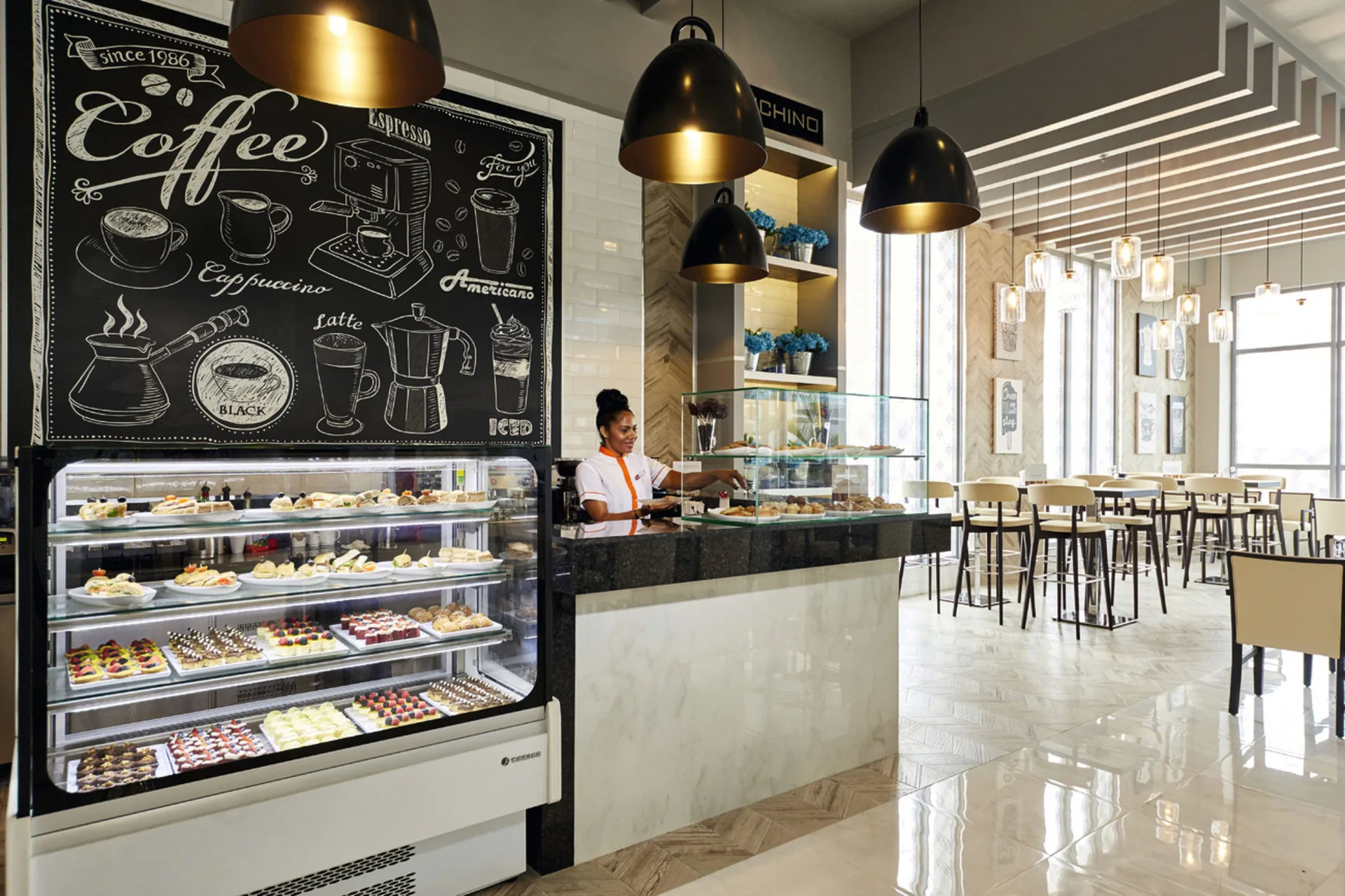 Coffee bar with pastry display and counter seating at Hotel Riu Palace Paradise Island.
