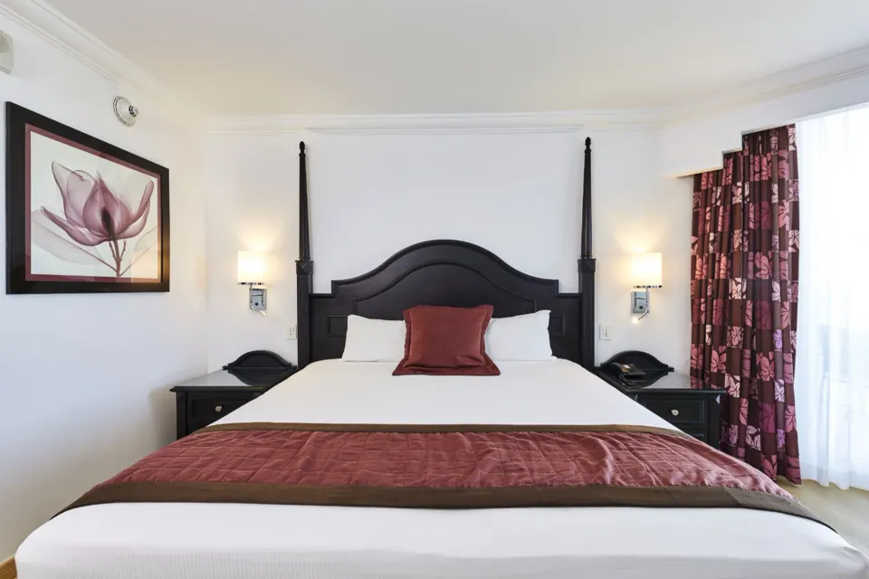 Junior Suite Ocean View bed with dark headboard at Hotel Riu Palace Paradise Island.