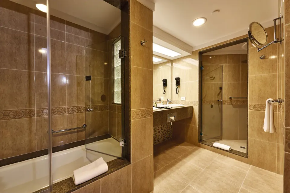 Standard Suite bathroom with tub, shower, and vanity at Hotel Riu Palace Paradise Island.