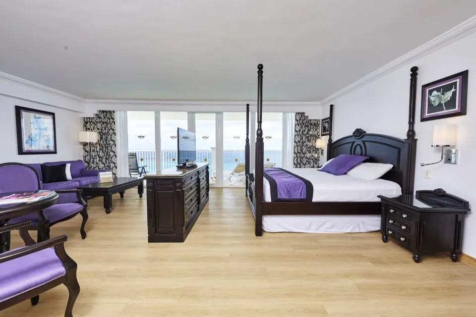 Oceanfront suite with four-poster bed and balcony at Hotel Riu Palace Paradise Island.
