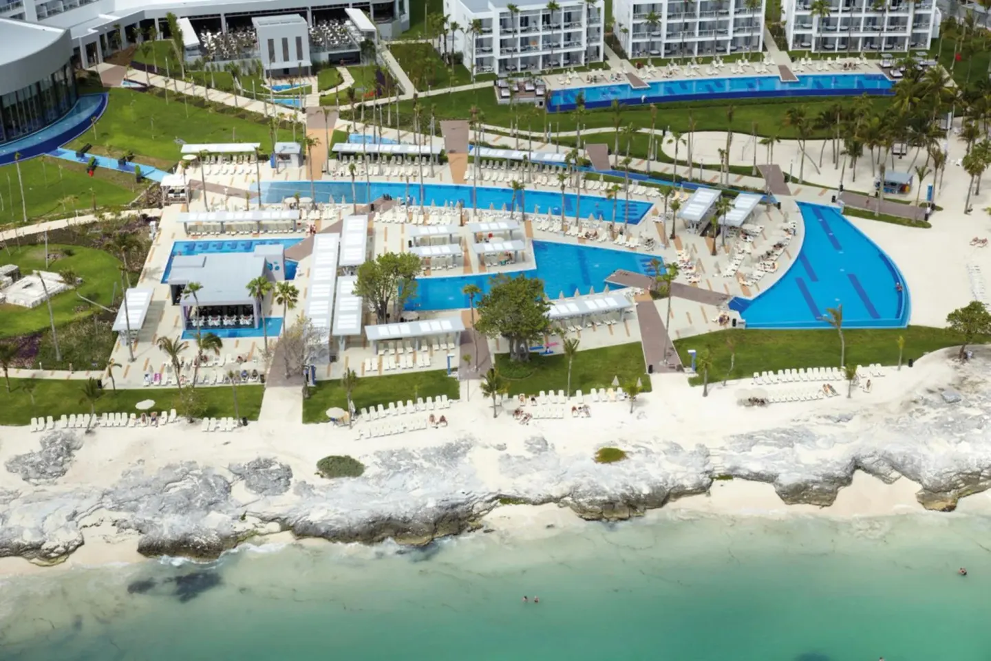 Aerial view of pools, gardens, and beachfront at Hotel Riu Palace Peninsula.