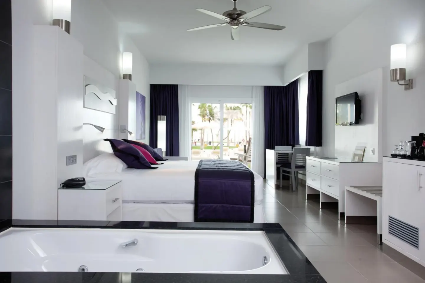 Bright guest room with king bed and in-room tub at Hotel Riu Palace Peninsula.