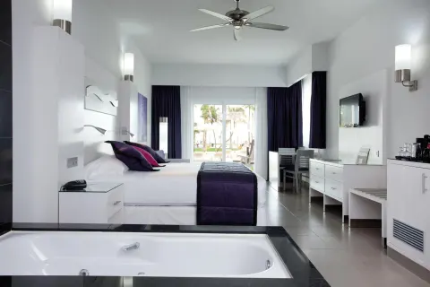 Bright guest room with king bed and in-room tub at Hotel Riu Palace Peninsula.