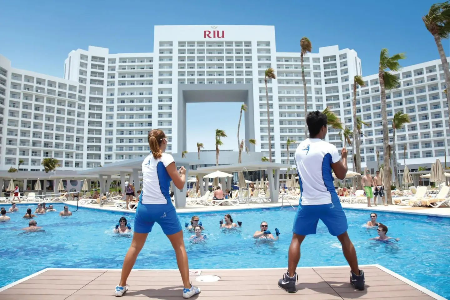 Pool fitness class in front of the white tower at Hotel Riu Palace Peninsula.