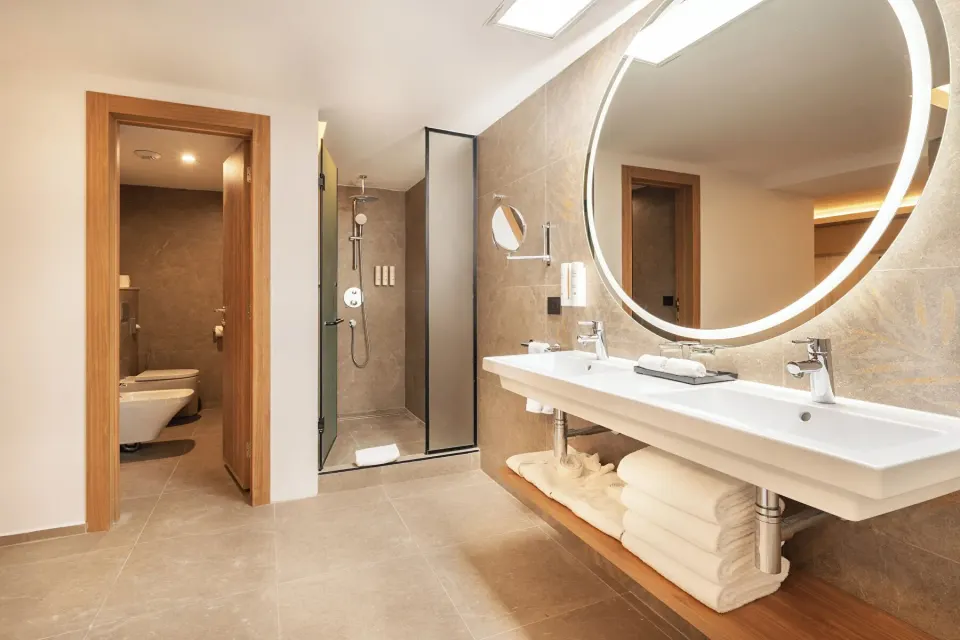 Bathroom vanity and walk-in shower in an Elite Club Suite Ocean View at Hotel Riu Palace Peninsula.