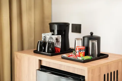 In-room coffee station and mini fridge in an Elite Club Suite Ocean View at Hotel Riu Palace Peninsula.
