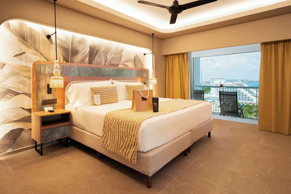King bed and balcony view in an Elite Club Suite Ocean View at Hotel Riu Palace Peninsula.