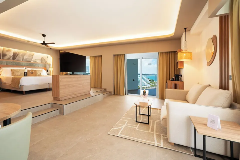 Spacious Elite Club Suite Ocean View with bed, lounge area and balcony at Hotel Riu Palace Peninsula.
