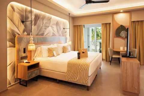 Elite Club Suite bedroom with king bed and balcony doors at Hotel Riu Palace Peninsula.