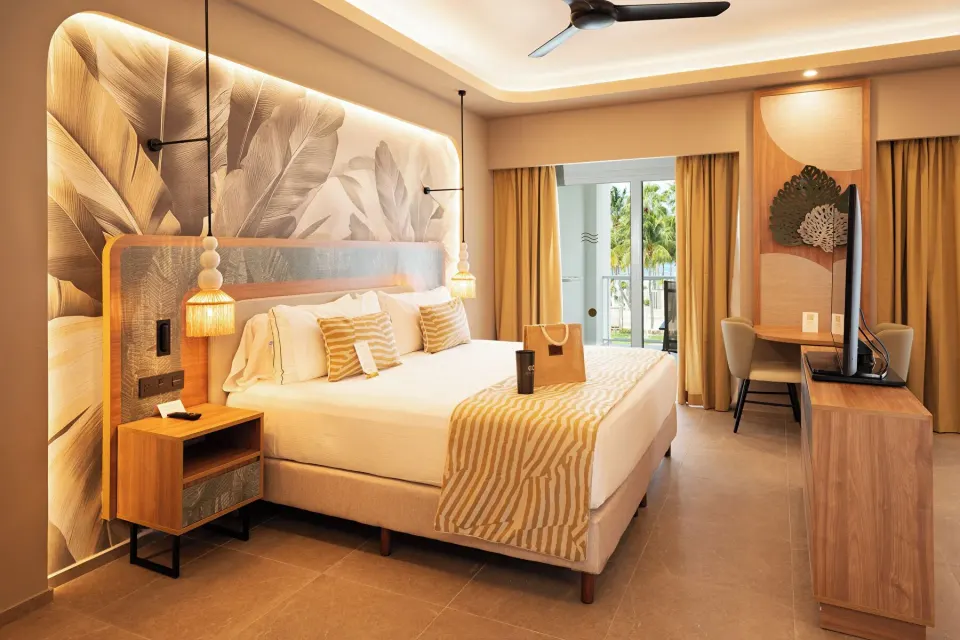 Elite Club Suite bedroom with king bed and balcony doors at Hotel Riu Palace Peninsula.
