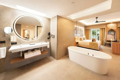 Elite Club Suite bathroom with soaking tub and king bed beyond at Hotel Riu Palace Peninsula.