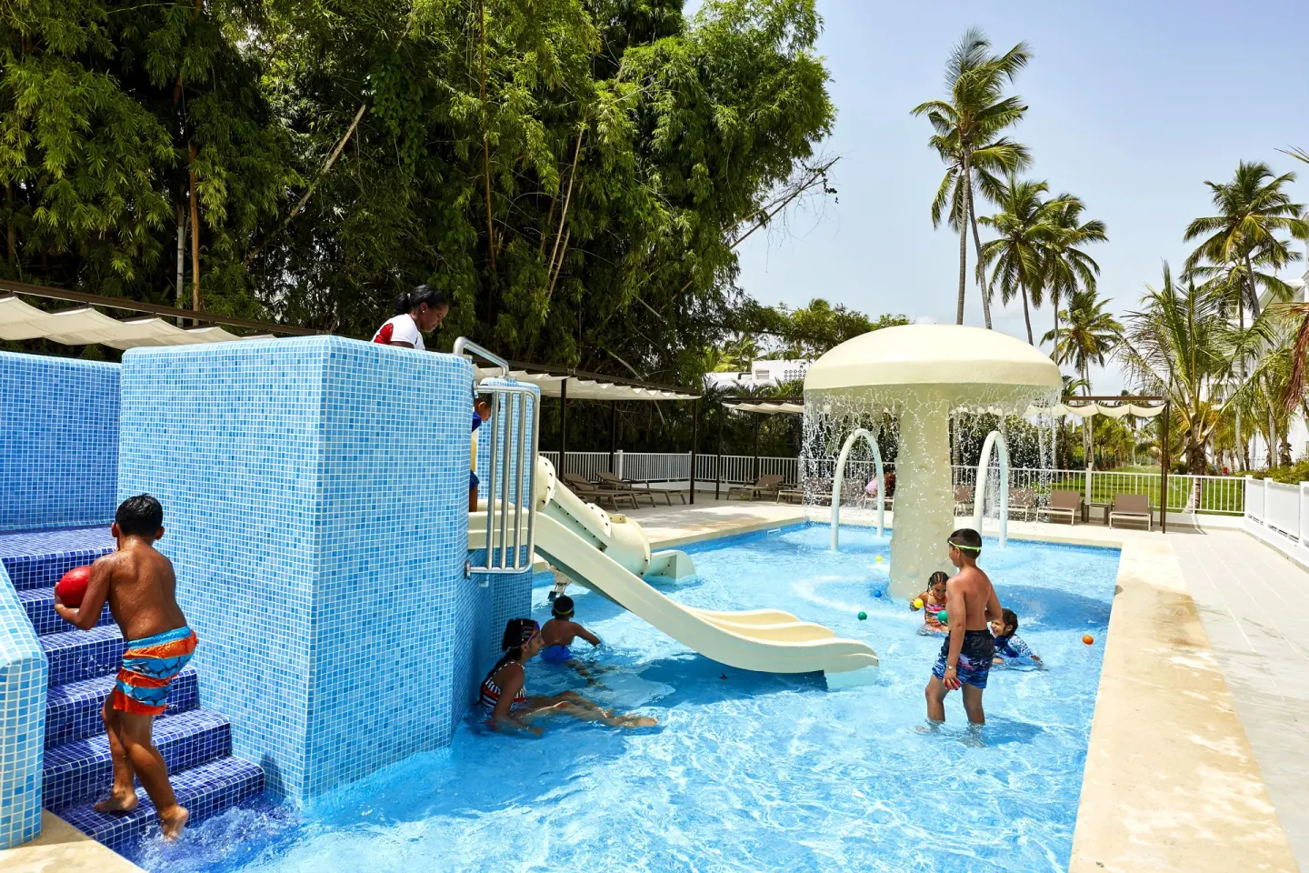 Children's splash pool with slide and water feature at Hotel Riu Palace Punta Cana.