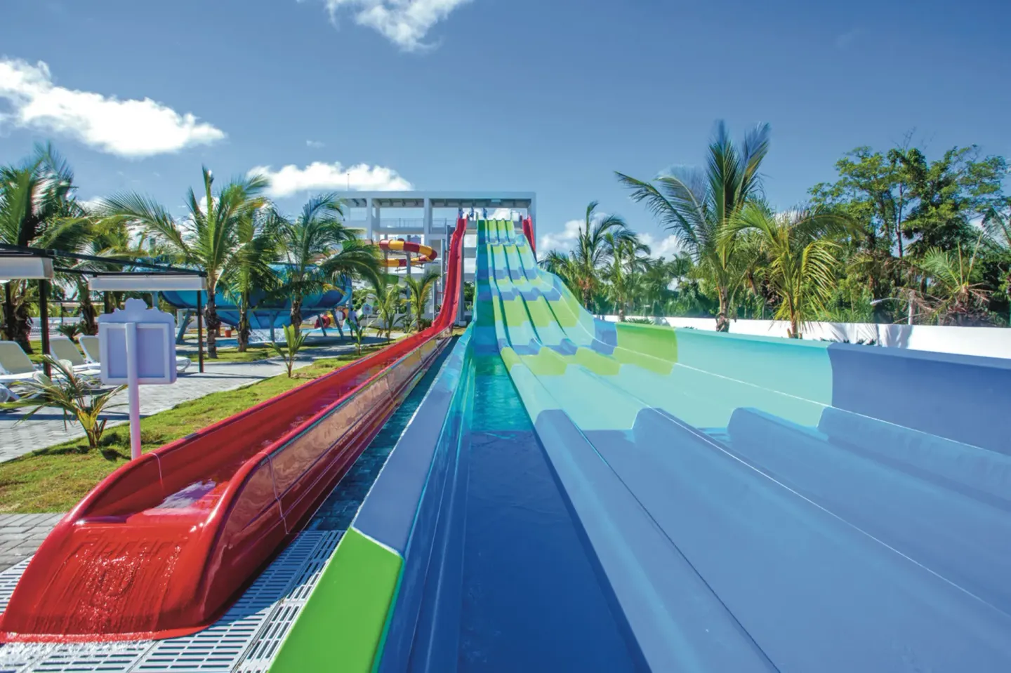 Multi-lane water slides with red and blue chutes at Hotel Riu Palace Punta Cana.