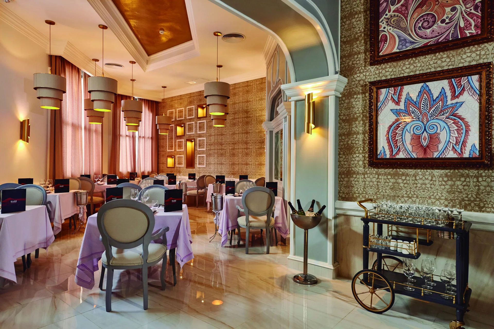 Elegant restaurant with white tablecloths and framed art at Hotel Riu Palace Punta Cana.
