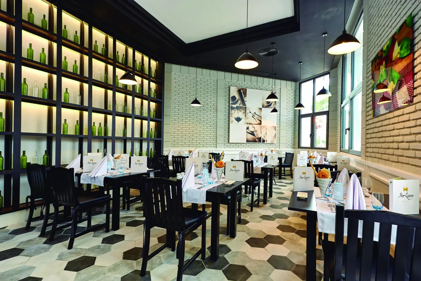 Italian restaurant dining room with bottle display wall at Hotel Riu Palace Punta Cana.