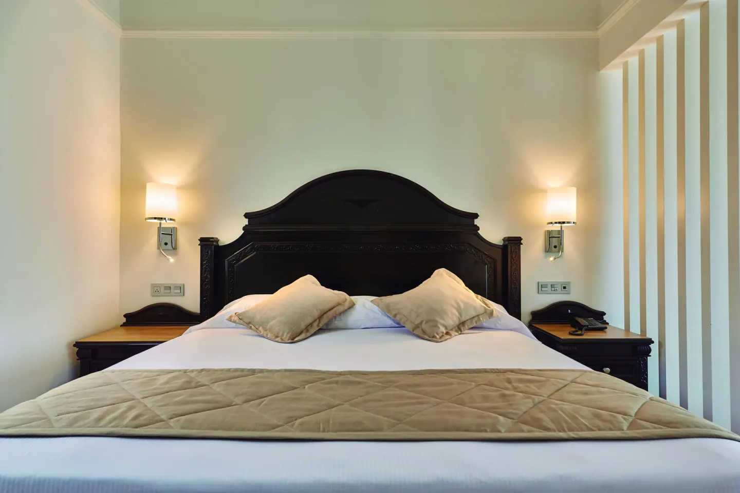 Junior Suite bed with bedside lamps at Hotel Riu Palace Punta Cana.