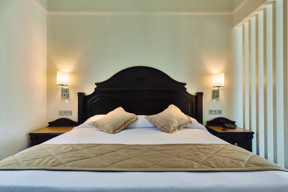 Junior Suite bed with bedside lamps at Hotel Riu Palace Punta Cana.