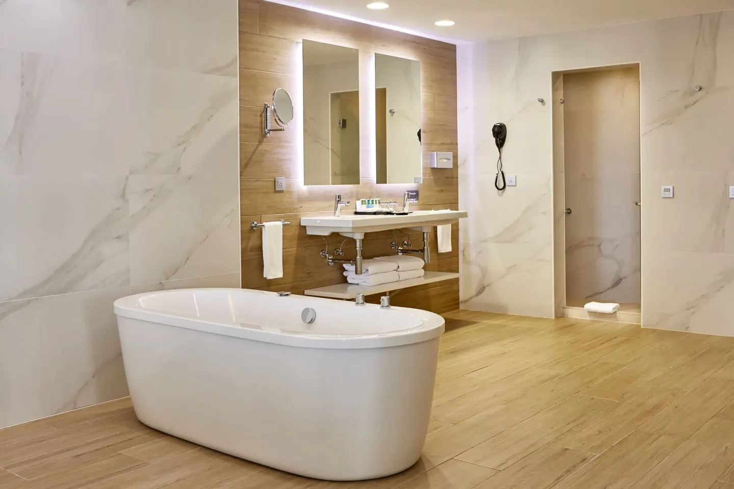 Suite bathroom with freestanding tub, double mirrors, vanity, and shower at Hotel Riu Palace Punta Cana.